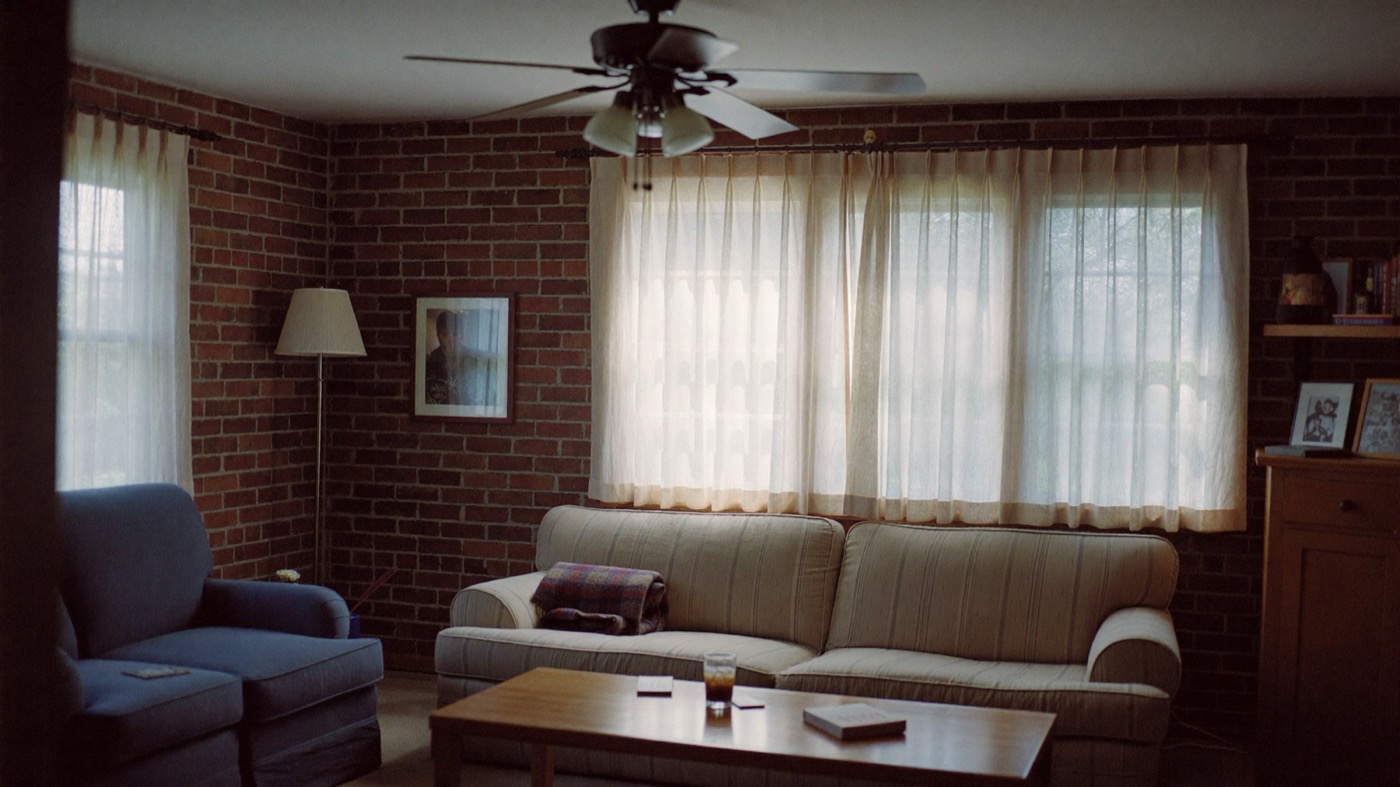 A calm, lived-in family room with soft window light and a ceiling fan